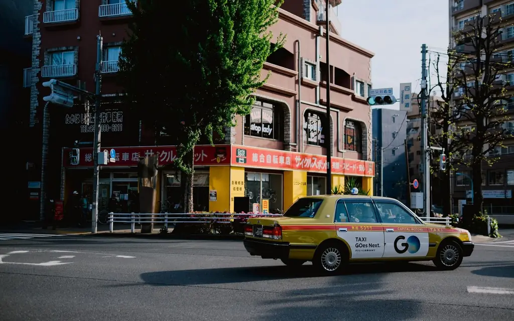 A vibrant Tokyo street featuring a classic Japanese taxi and urban architecture.