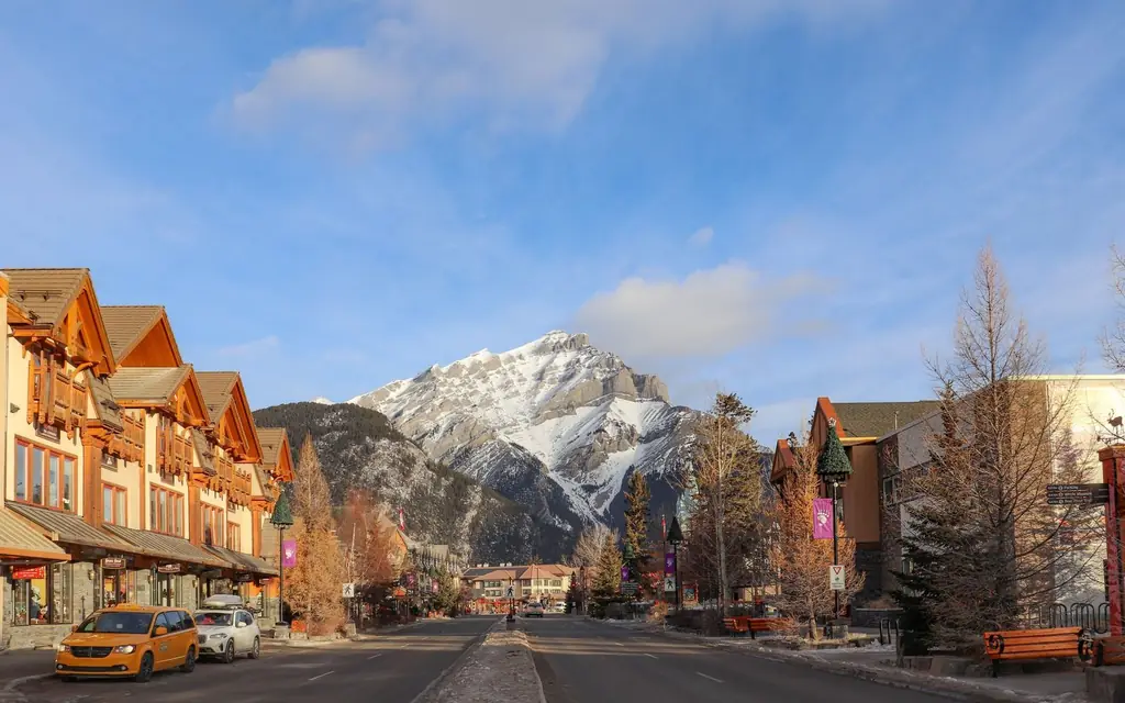 Charming Banff Avenue with snowy mountains in Banff, Alberta, highlighting winter charm.
